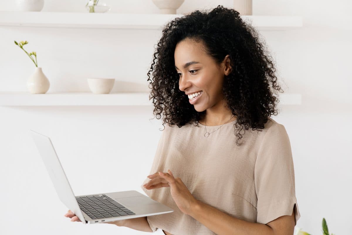 A developer smiling while working on a laptop